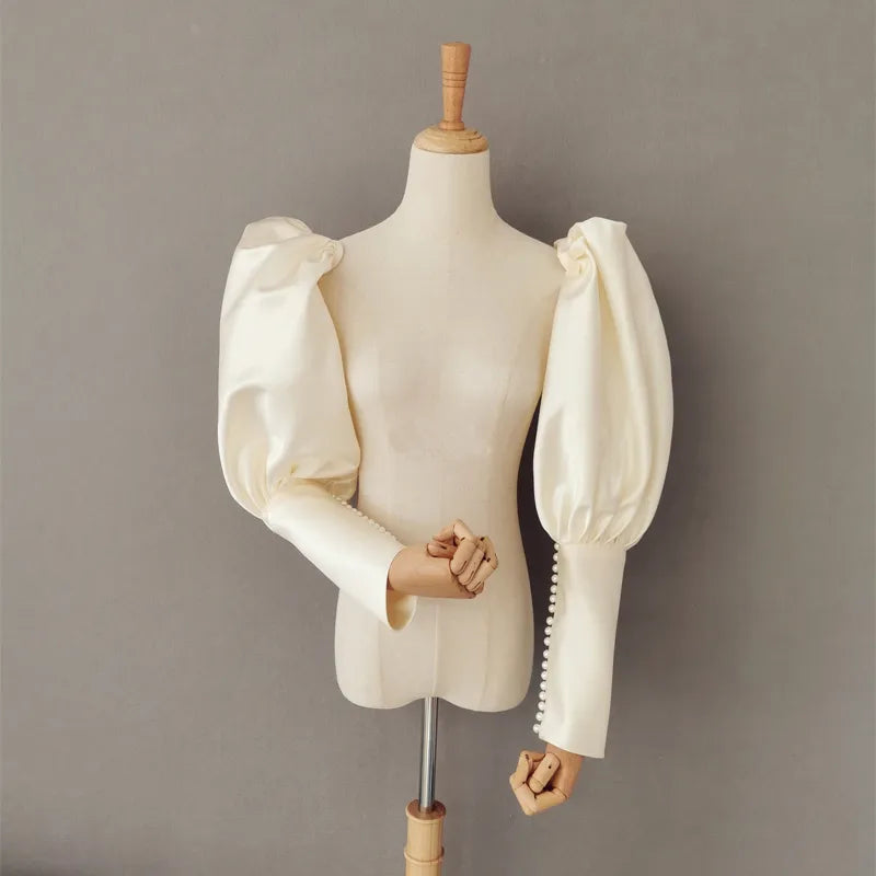 Elegant satin detachable bridal sleeve with pearl buttons, featuring a traditional puff design in soft ivory color.