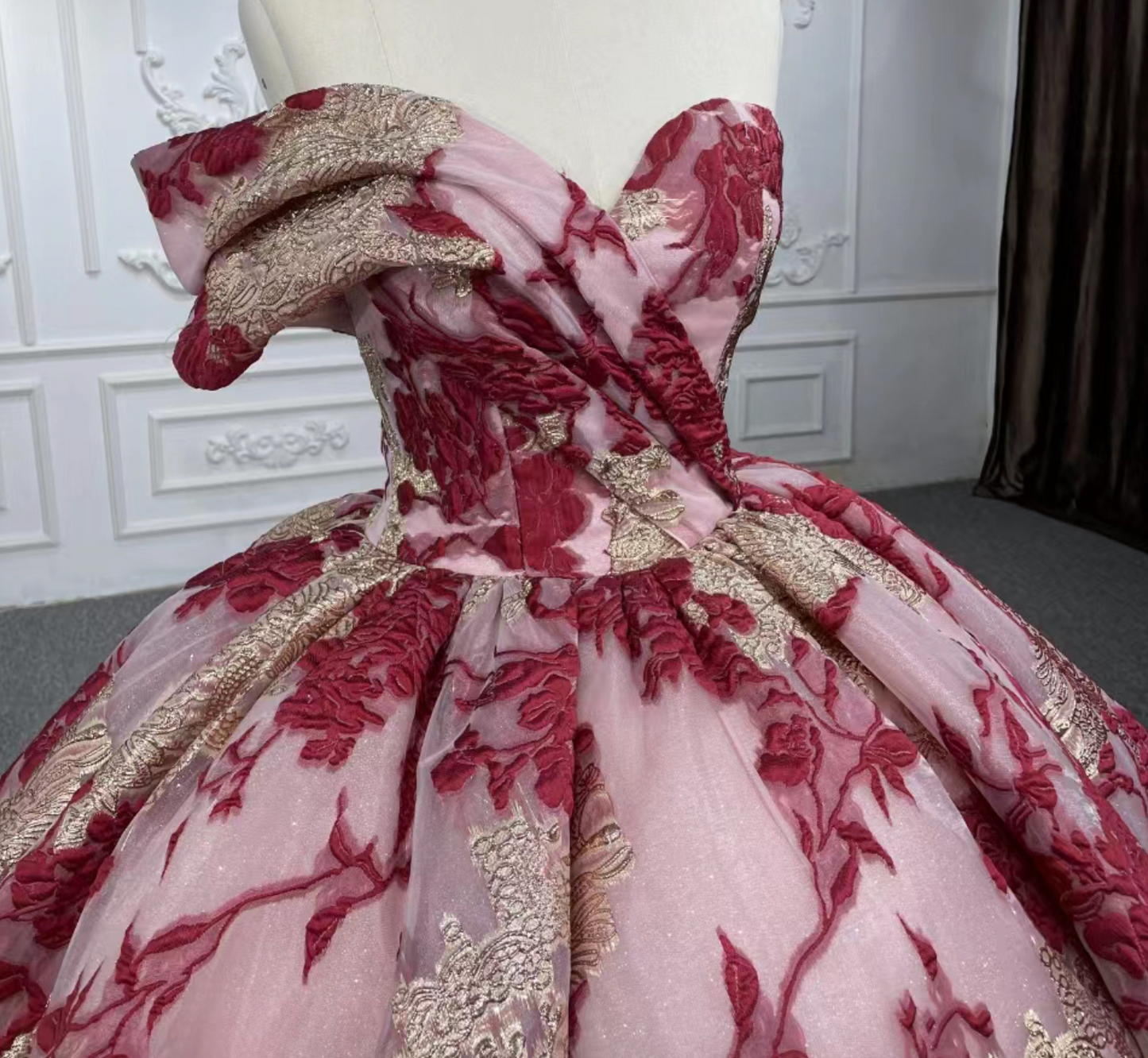 Quinceanera Dress Multi Color Gold Burgundy Ball Gown, Showcasing exquisite details, this dramatic ballgown features an off-shoulder one-cuff pleated sleeve, a draped bodice