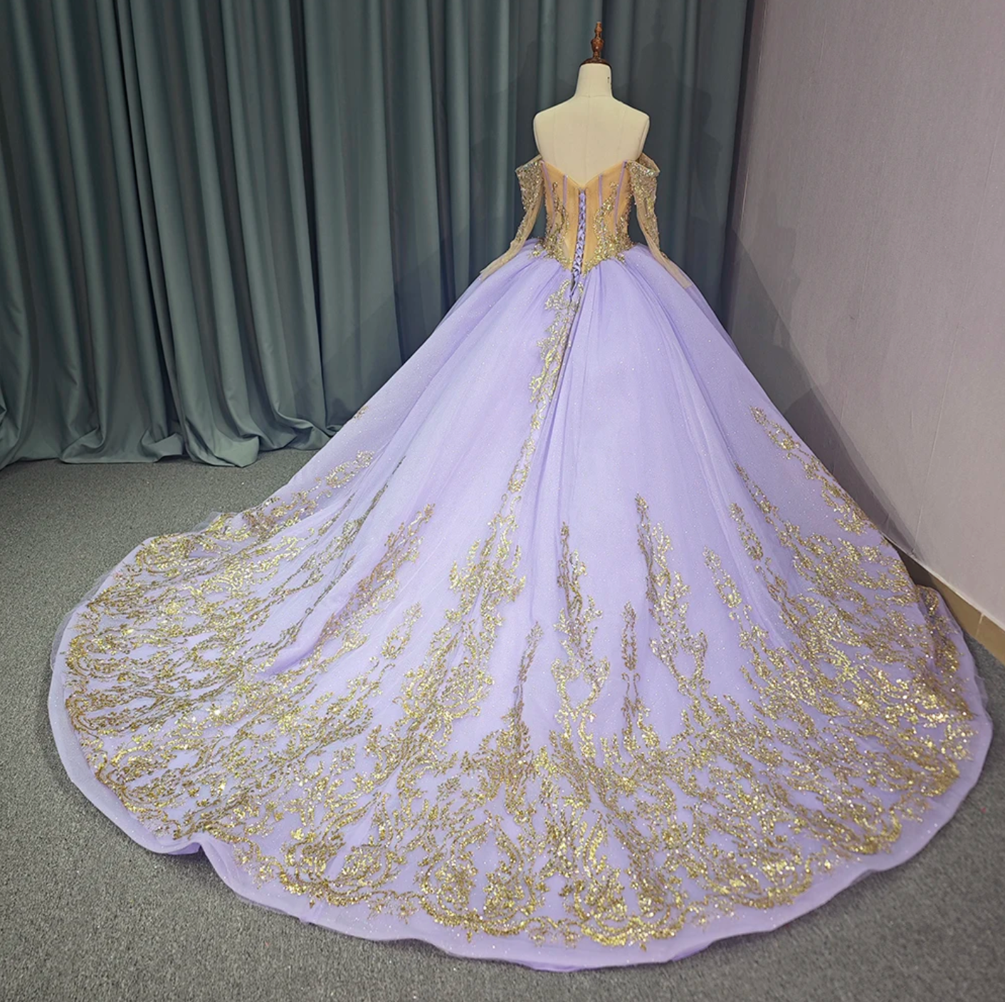 Quinceanera ball gown in purple with gold accents, featuring a lace-up back and elegant full skirt.