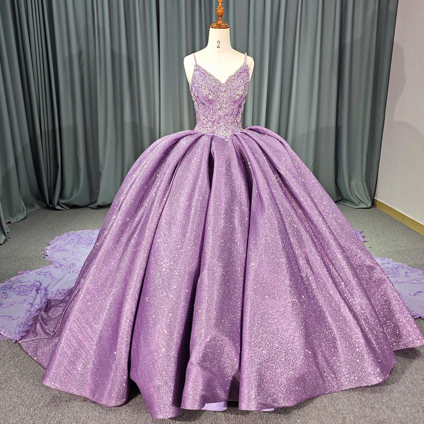 Purple shiny quinceanera dress with a voluminous skirt and intricate beaded lace bodice, perfect for special celebrations.