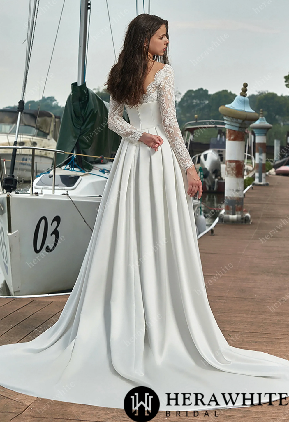 Back view of a satin cover and lace sheath wedding dress with long sleeves, featuring a flowing train and vintage details.
