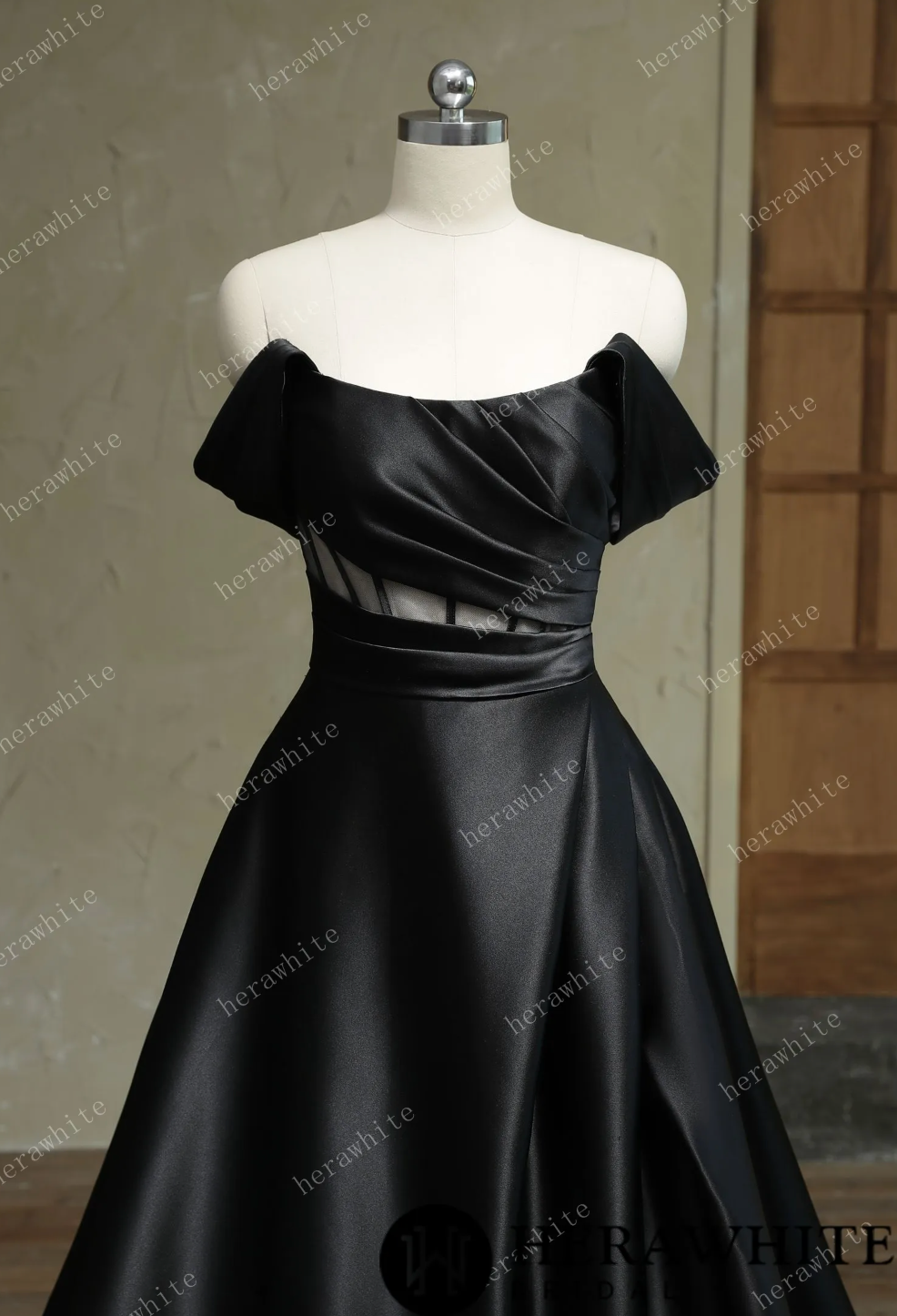 Elegant off-shoulder black Mikado wedding dress with illusion cutouts and a flowing A-line skirt.