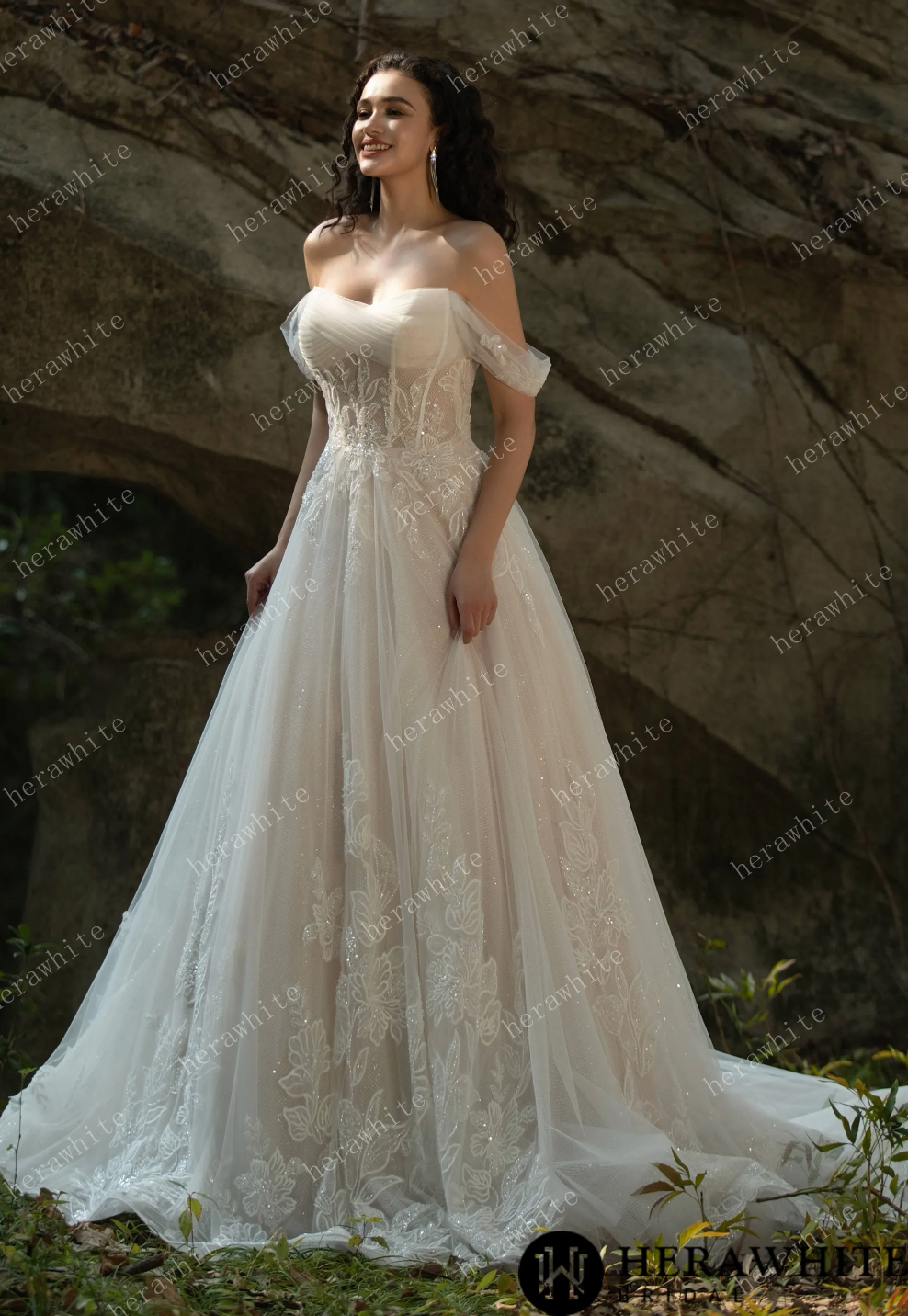 Off the shoulder corset wedding dress with floral appliqués and flowing tulle skirt, showcasing elegant style.
