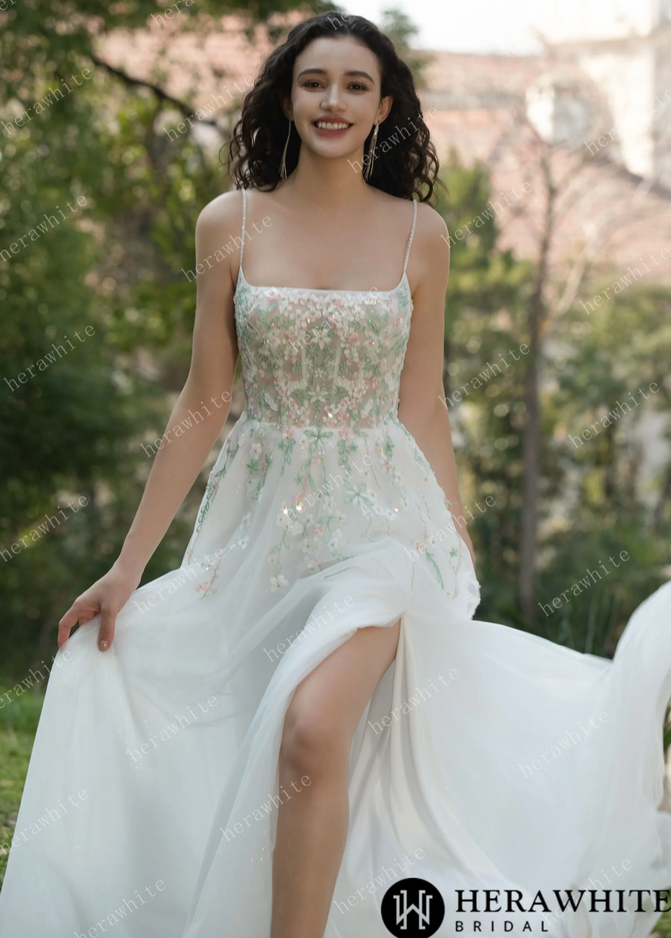 Floral spaghetti straps square neck wedding dress with tulle skirt and vibrant embroidery, showcasing bridal elegance outdoors.