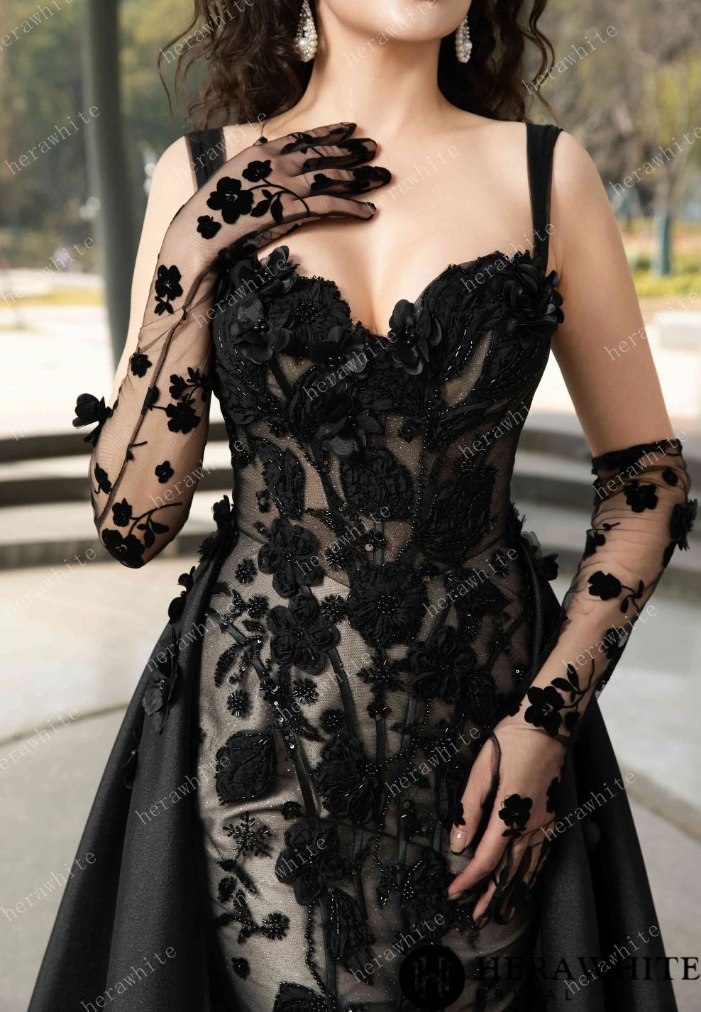 Elegant black wedding dress with sweetheart neckline and lace appliqués, paired with matching gloves for a vintage touch.