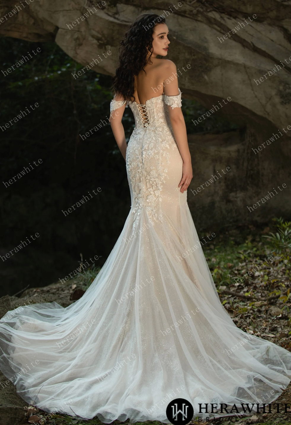 Back view of a stunning sequined lace off-the-shoulder wedding dress with a fit and flare silhouette and dramatic train.