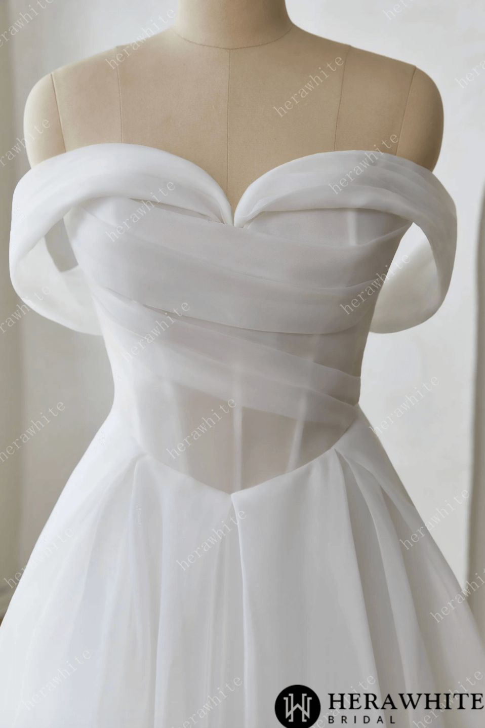 Elegant off-the-shoulder A-line wedding dress with sweetheart neckline and draped corset bodice in organza satin.