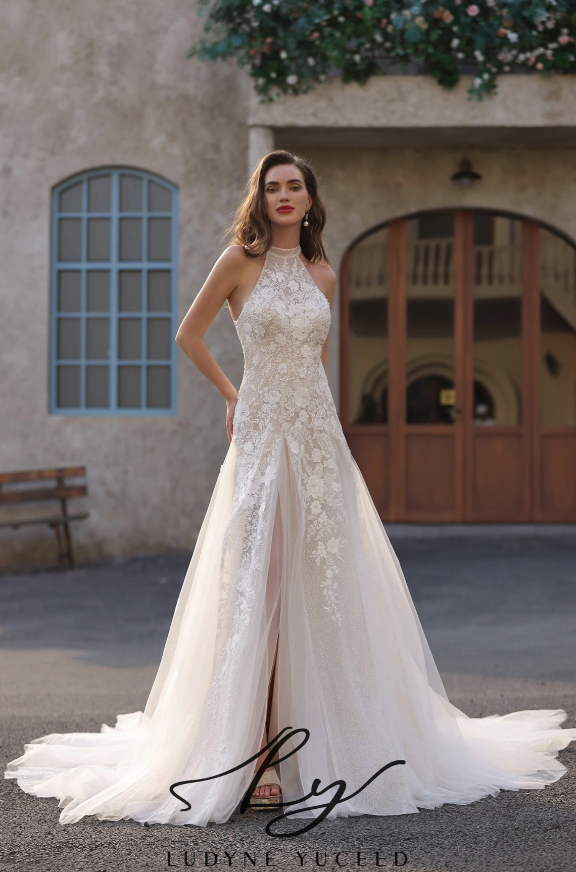 Wedding Dress Floral Lace Halter Neck A Line Bridal Gown, this wedding dress showcases a high neck halter design, exuding elegance and grace. The bodice, crafted from intricate floral lace, hugs the figure beautifully, while the sheer tulle skirt features a daring side slit for a touch o