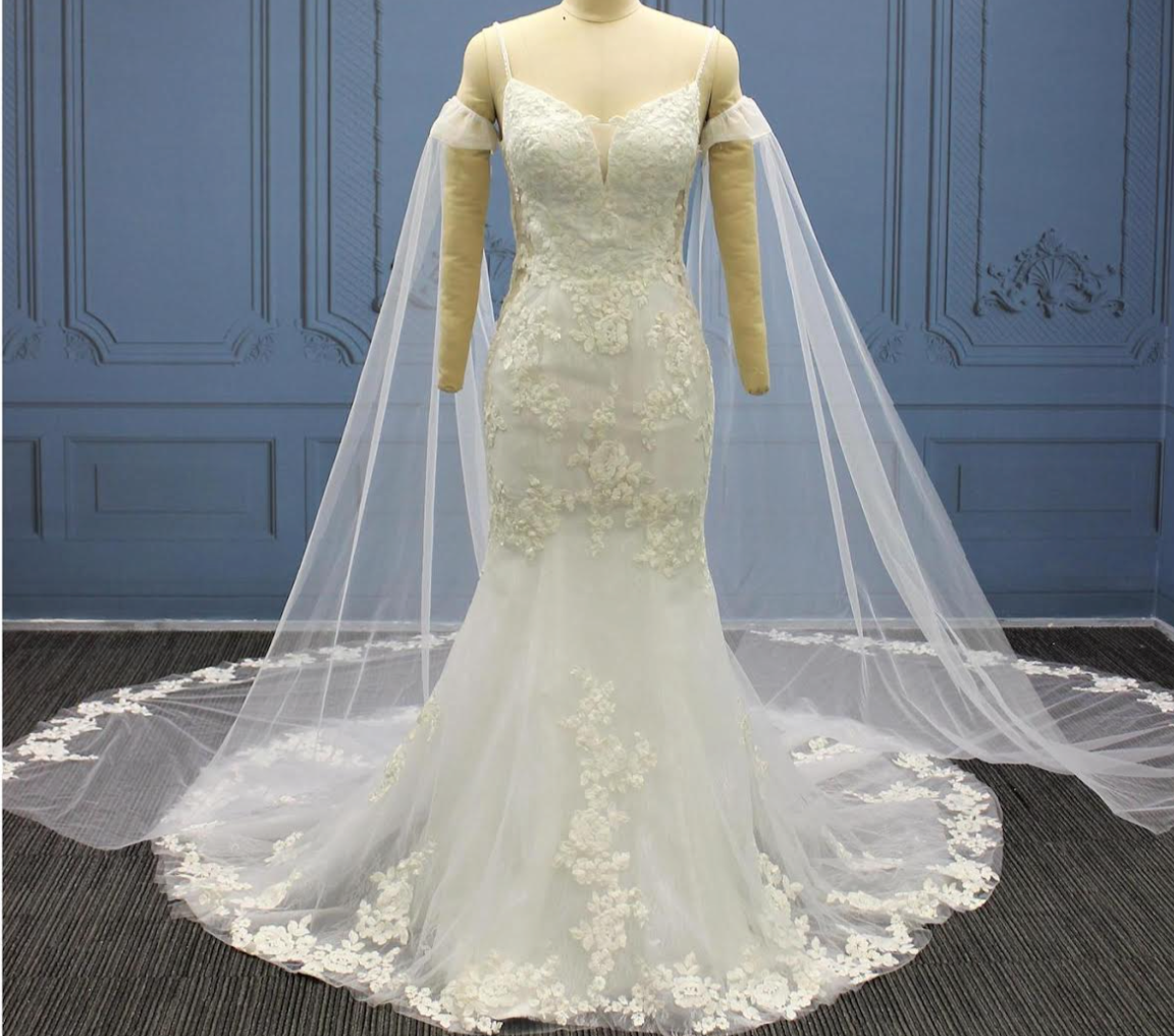Plus Size Wedding Dress with tulle lace cape and floral detailing on a mermaid silhouette, showcased on a mannequin.