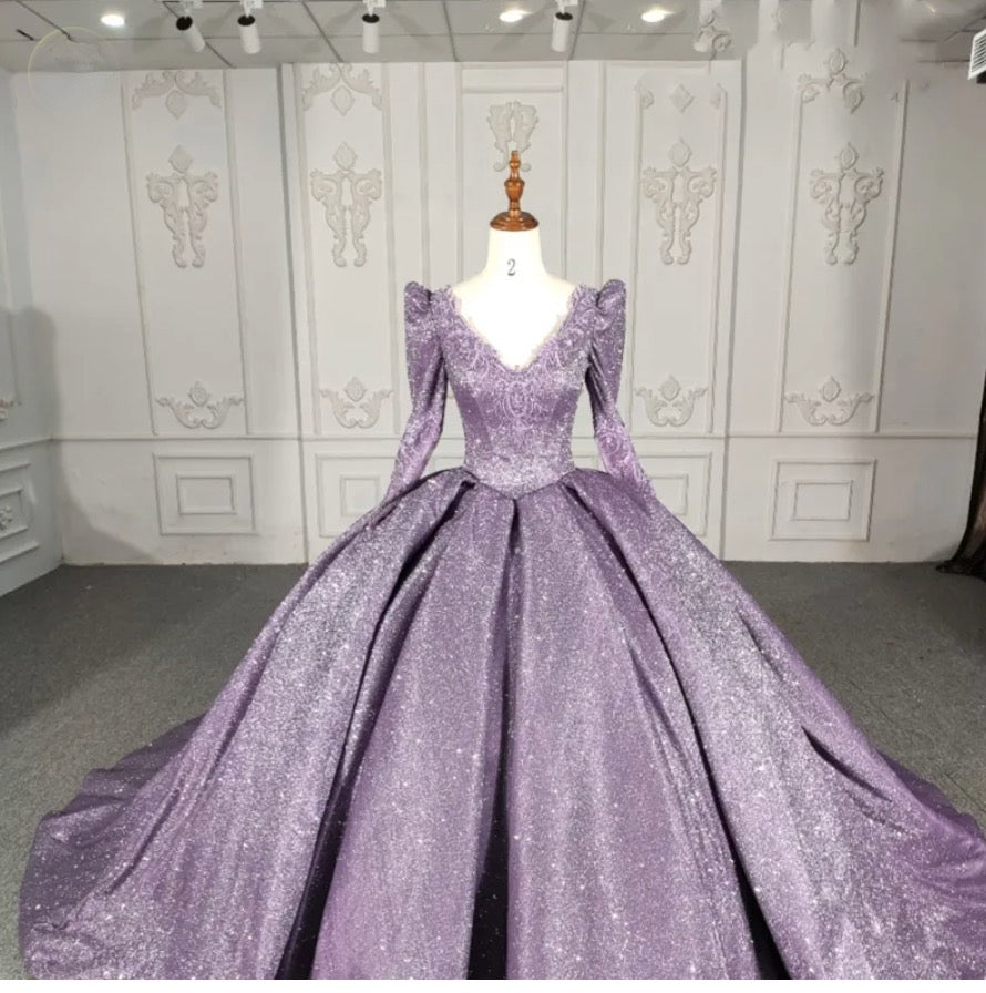 Purple long sleeve A-line party ball gown with beading and a full gathered skirt, showcasing a glamorous design.