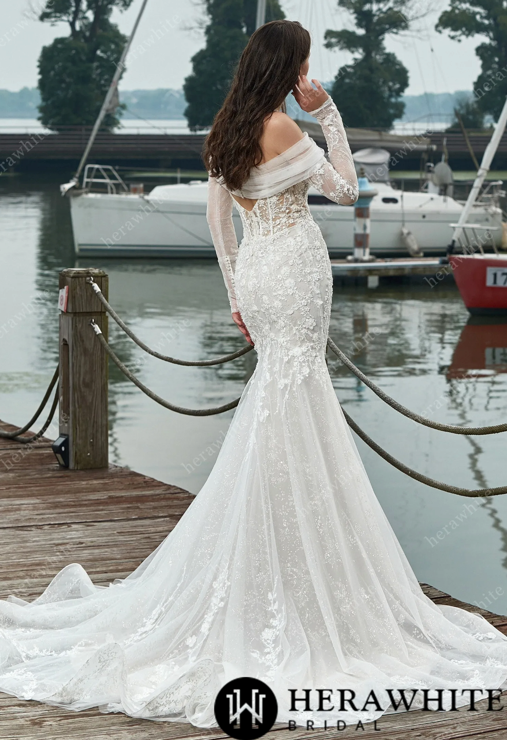 Elegant long sleeve corset wedding dress with lace and floral details, set against a scenic marina backdrop.