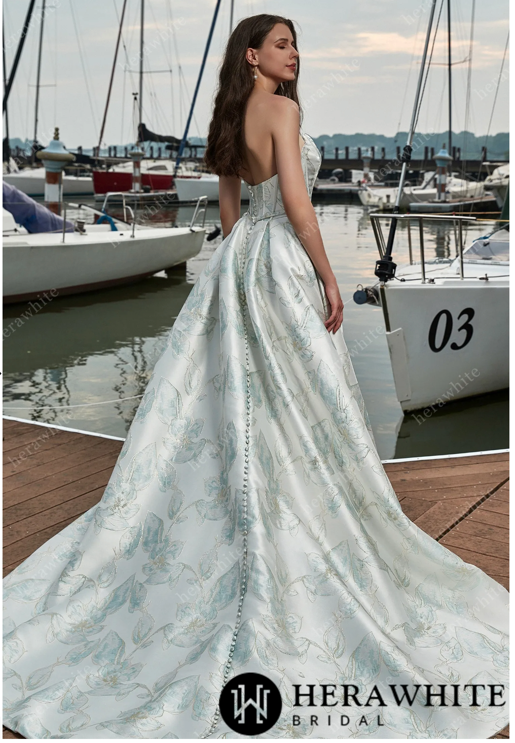 Elegant satin sleeveless A-line wedding dress with a thigh-high slit and intricate floral pattern by Herawhite Bridal.