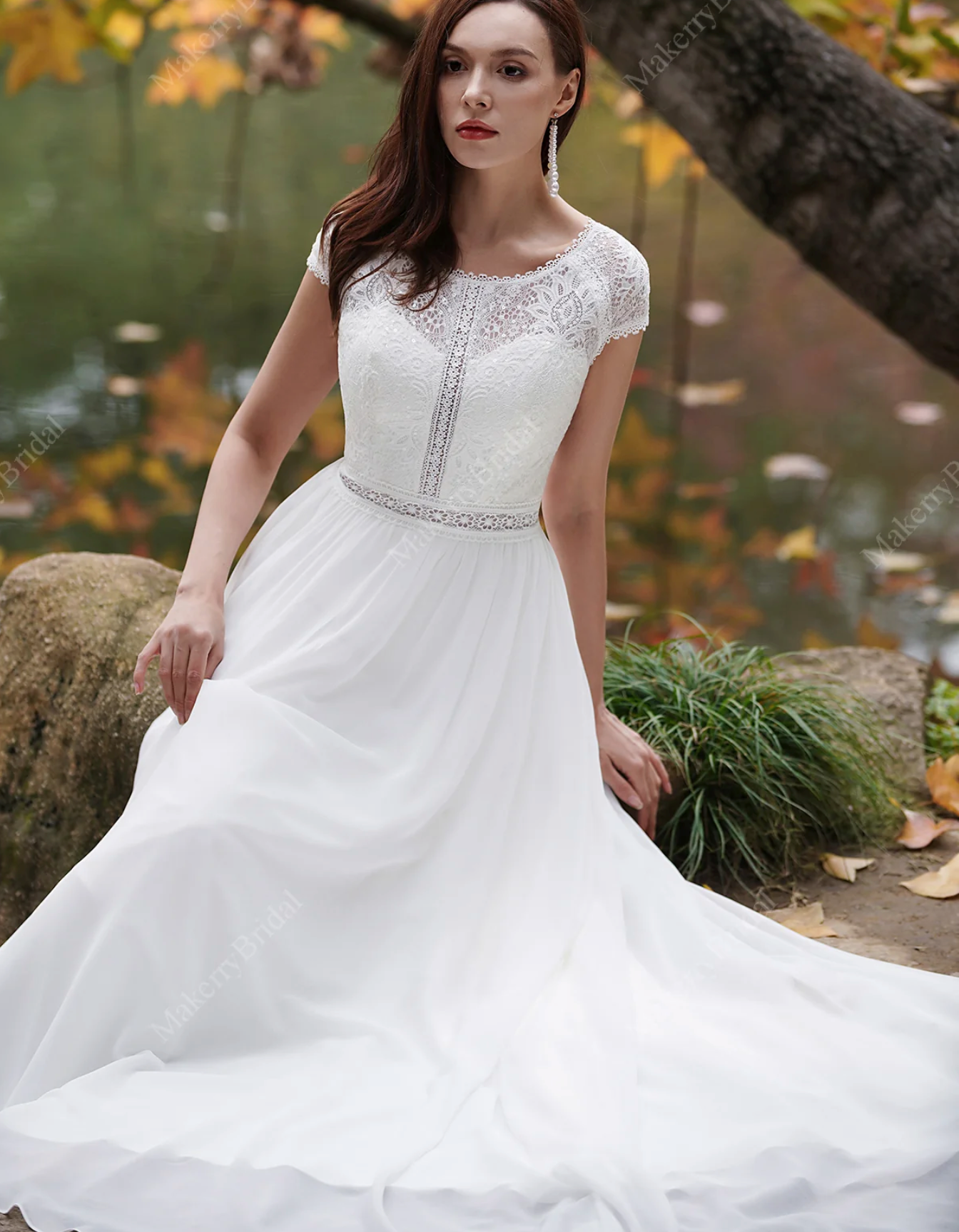 Elegant ivory chiffon bohemian wedding dress with cap sleeves, lace detail, and flowing skirt, perfect for a romantic look.